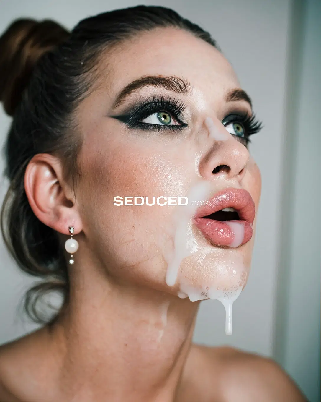 Cumshot porn image: cum drunk, amateur photo, tight three-quarter face close-up of a 28-year-old Russian MILF with a high messy bun with loose strands, thick cum hanging from her lower lip and chin, looking dazed with…